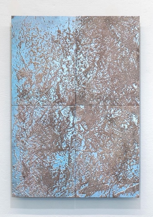 textured metal surface with abstract image in pale blue and metallic silver
